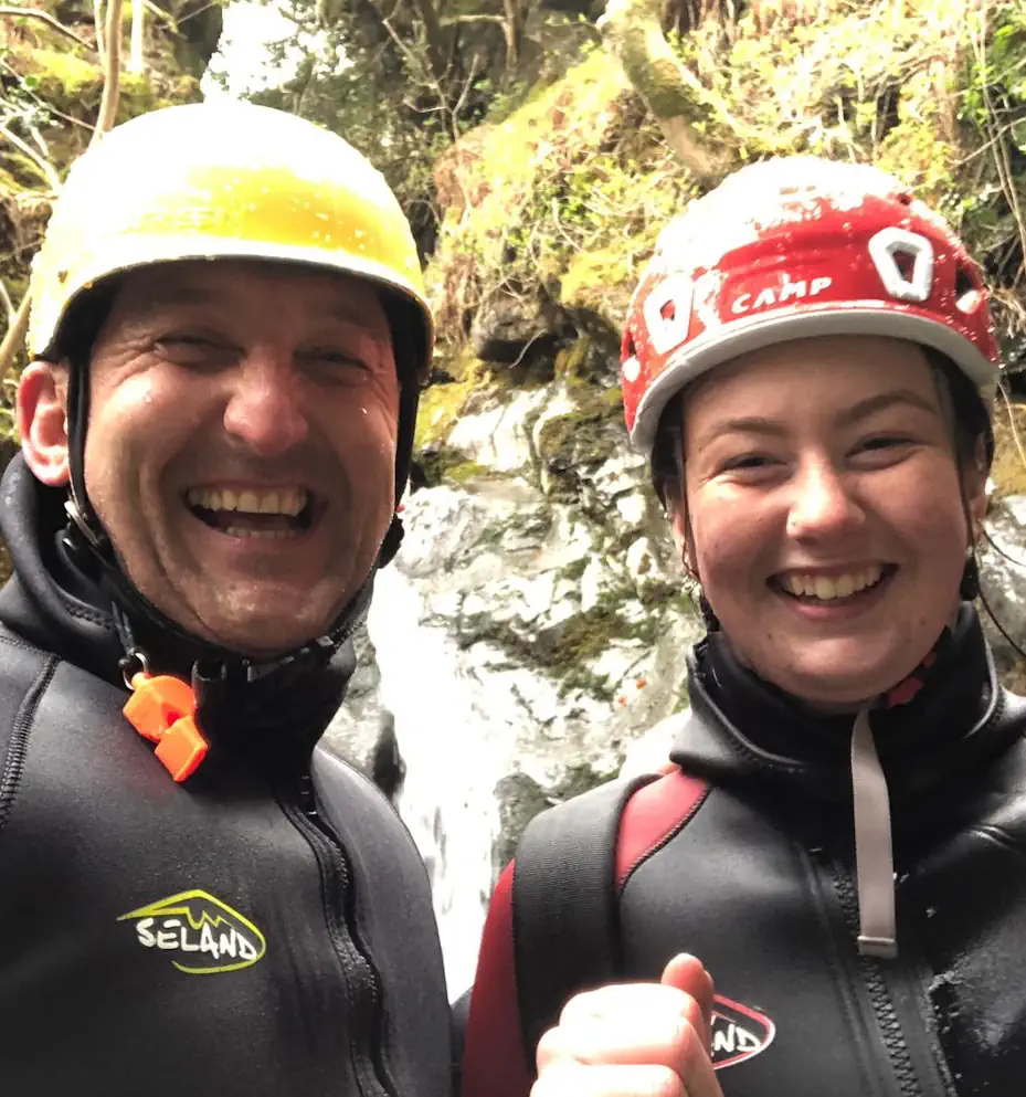 Lee Simpson and woman laughing in front of a waterfall