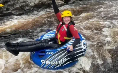 Woman smiling on a rubber ring on a river