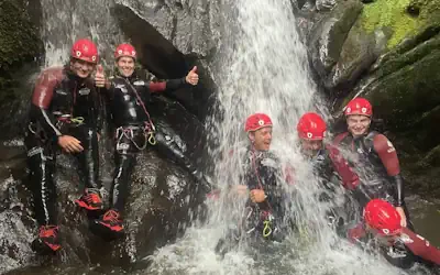 Group of ghyll scramblers under a waterfall