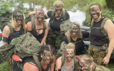 Hen do group in camouflage on a river in the Lake District