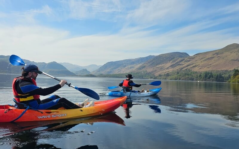 Two kayakers on Derwentwater, with Catbells in the distance