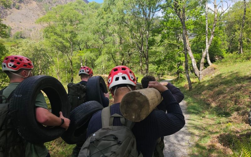 Men carrying a log through the Lake District